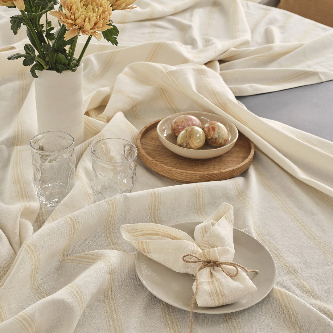 Compliments linneduk Brise, Gul - 200 x 200 cm, på bordet