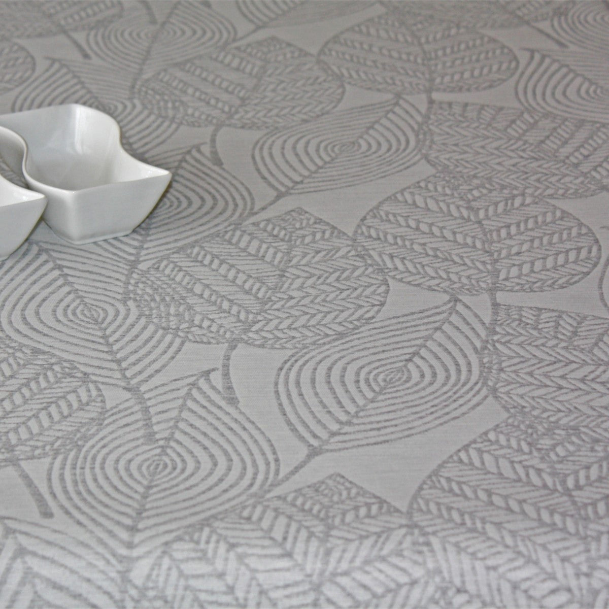 Amberes Jacquard, grå blad. Jacquardvävd textilvaxduk med grå streckade blad på naturfärgad bakgrund