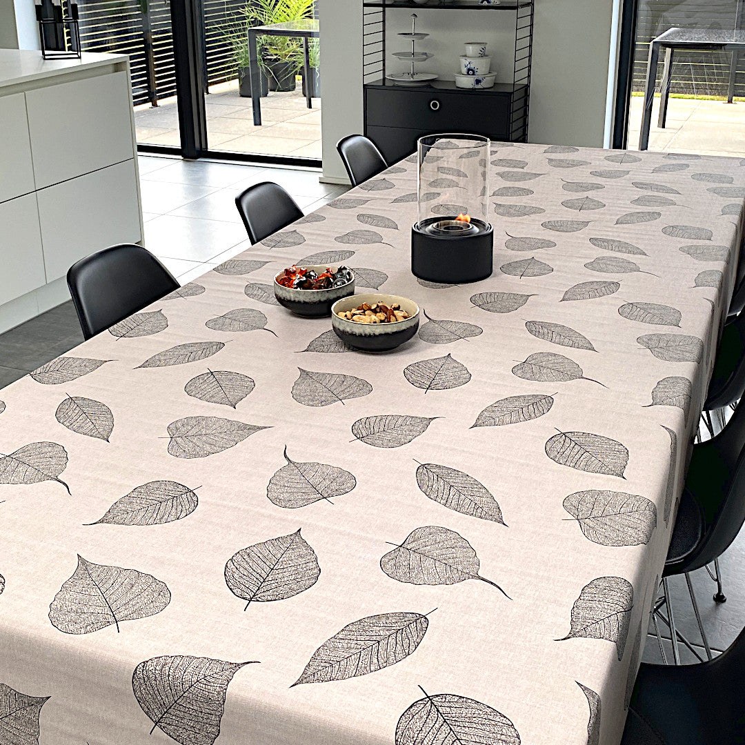 Vax duk med svarta detaljerade blad liggande på bordet