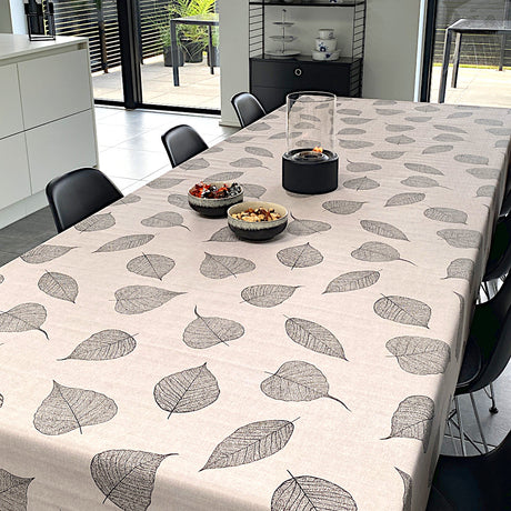 Vax duk med svarta detaljerade blad liggande på bordet