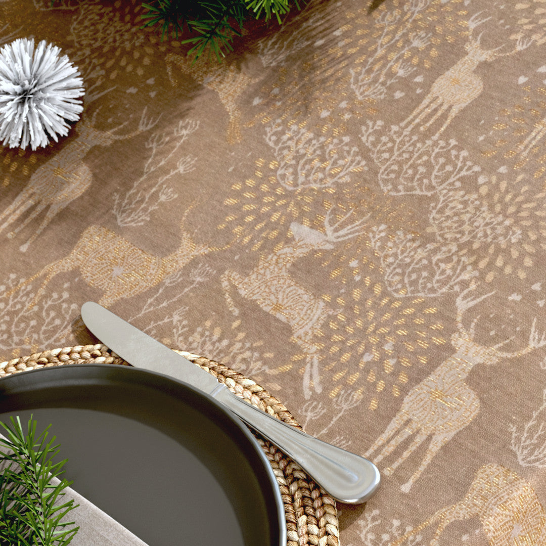 Närbild av julduken Golden Reindeers med gyllene renar på en sandfärgad bakgrund