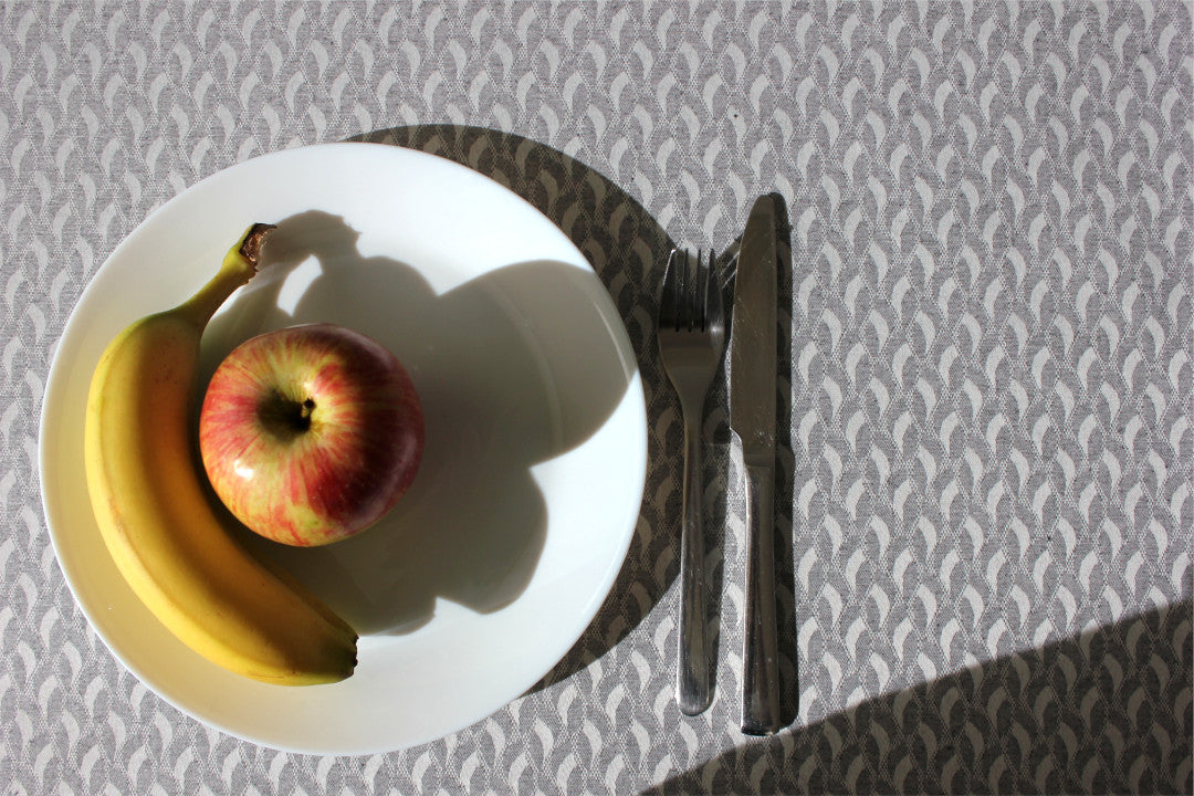 Munch Grey textilvaxduk med eleganta mjuka kurvor på ett festligt dukat bord