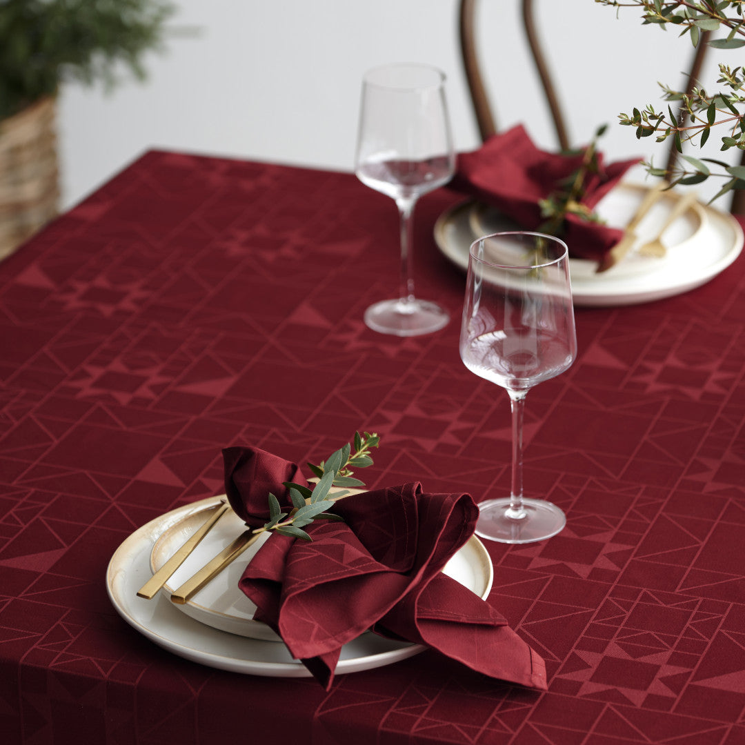 Närbild av dukning med Södahl Star Damast julduk Röd och glaspåycknad 140x370