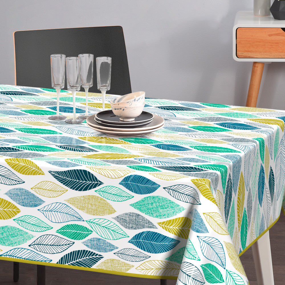 På bordet Cascade - Lätt präglad vaxduk med blad i blå och gröna nyanser.