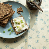 Mimosi North – Captain Cook vaxduk med små grafiska blommor närbild