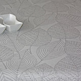 Amberes Jacquard, grå blad.  Jacquardvävd textilvaxduk med grå streckade blad på naturfärgad bakgrund